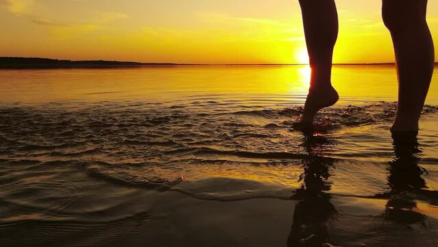 Feet running on the beach at sunset