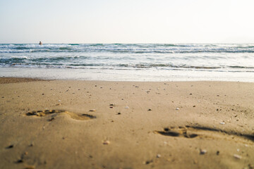 footprint on beach sand near sea, sunset, selective focus