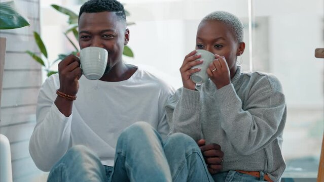 Black couple, drinking coffee and relax from moving new home, real estate and apartment. Happy woman, smile man and cheers celebration with tea mugs for happiness, calm and peace in living room house