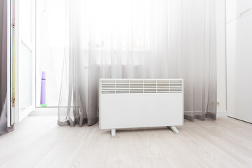 Modern electric infrared heater in living room - obrazy, fototapety, plakaty