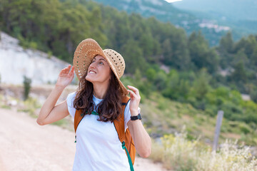 young girl in a straw hat and a backpack.