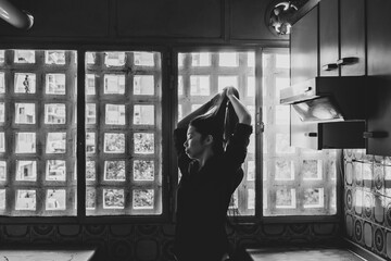 Beautiful asian woman dancing in vintage kitchen. Black and white