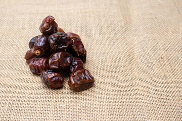 Closeup of Date Palm Fruit or Phoenix Dactylifera Isolated on Burlap Fabric with Copy Space
