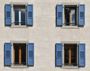 Exterior of a building with four windows with open blue shutters, France, Europe
