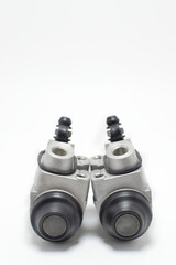 Bombas de frenos auxiliares para automovil sobre un fondo blanco, toma vertical.