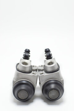 Bombas de frenos auxiliares para automovil sobre un fondo blanco, toma vertical.