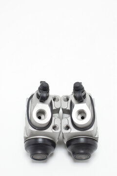 Bombas de frenos auxiliares para automovil sobre un fondo blanco, toma vertical, vista para entrada de lineas de frenos.