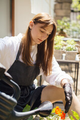 Woman florist watering plants in a flower shop - stock photo.