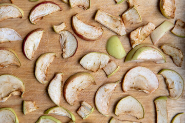 Sliced apple slices are laid out on a cutting board and dried in the kitchen. Dried apples