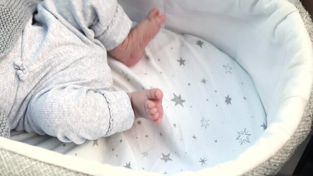 1080p slow motion footage video. Close up newborn legs baby child lying in baby carriage stroller buggy having fun playing, looking at her mother, smiling infant. Outside walking in pushchair, fresh a