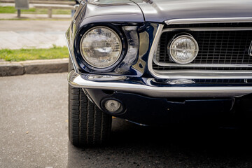 Detail of the headlight or front left light of a retro collector's car from the 60s. Mobility concept.