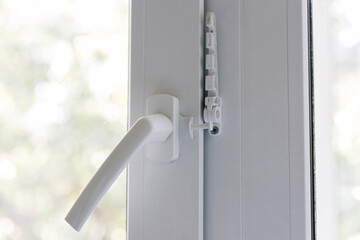 Close-up of a balcony door handle, double-glazed window fixing with a latch and a comb, a door frame. The concept of repairing doors and windows of a house