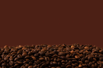 Brown roasted coffee beans on dark brown background