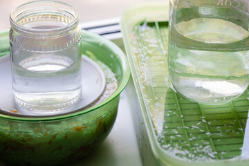 Pickling sauerkraut in plastic containers on the windowsill, glass jars with water, close-up. The concept of food from fermented canned vegetables