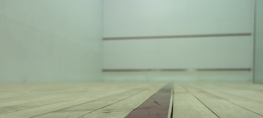 selective focus on a section of wood planking at floor level inside a racquet ball court