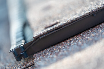 Ridge cap vent installed on a shingle roof for passive attic ventilation on a residential house. 