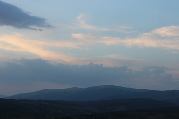 Fototapeta na wymiar Sun before dawn over the mountains with cloudy sky 