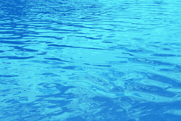 Fototapeta premium Vector illustration of water ripple texture background. Wavy water surface during sunset, golden light reflecting in the water. 