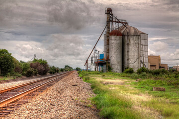Fototapeta na wymiar Grain Bins Along The Railroad Track in Waldenberg Arkansas