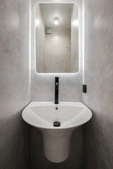 Faucet with ceramic sink with mirror in the bathroom