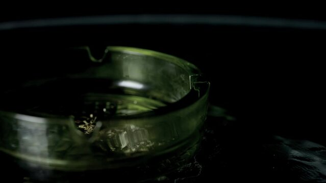 Lit cigarette burning in ashtray close up.