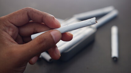 Man hand holding a cigarette, weed, ganja, marijuana. Unhealthy lifestyle concept 