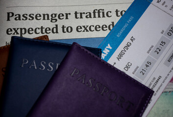 Newspaper headline with passport and ticket. High passenger traffic.