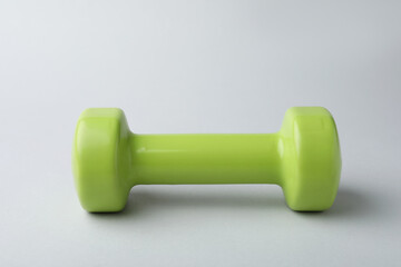 One new green vinyl dumbbell on light background