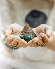 Healing woman dressed in a white robe in the middle of a forest. Holding a precious stone in the...