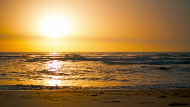 Sunrise landscape Ursa beach with orange sun reflecting Atlantic ocean surface