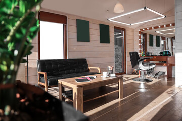 Stylish barbershop interior with hairdresser workplace, leather sofa and coffee table