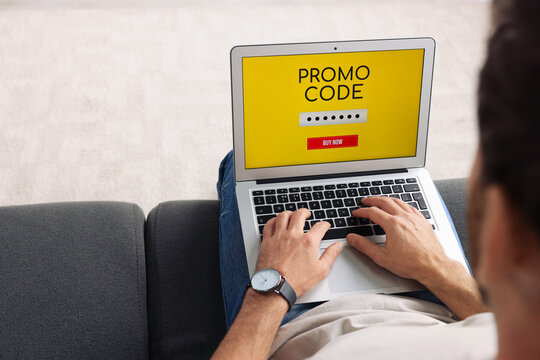 Man holding laptop with activated promo code on sofa, closeup