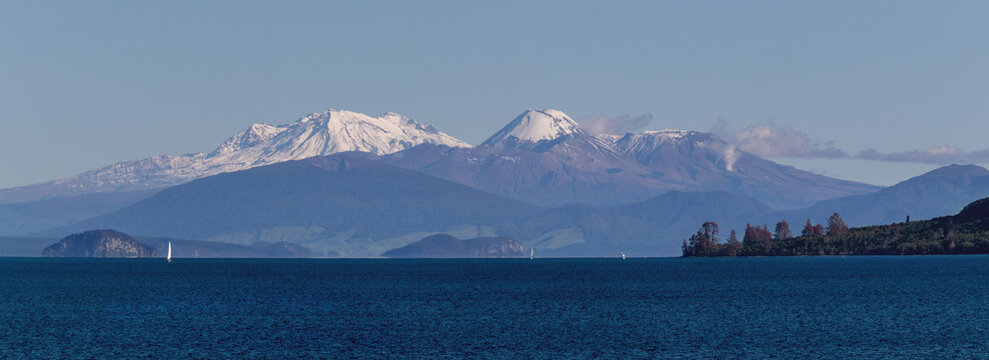 Snow capped volcanoes over lake Taupo