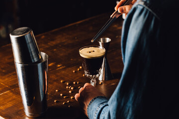 Fototapeta na wymiar barman garnishing an espresso martini cocktail with coffee beans