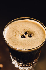 close up of espresso martini cocktail in a fancy elegant glass with coffee beans