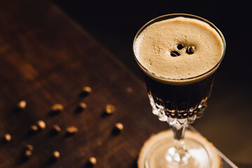 detail of espresso martini cocktail in a fancy elegant glass with coffee beans