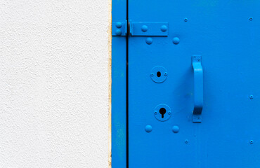 A blue door on a concrete wall