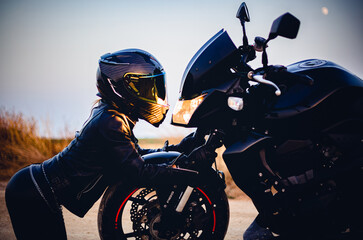 sensual biker woman looking face to face at her motorcycle