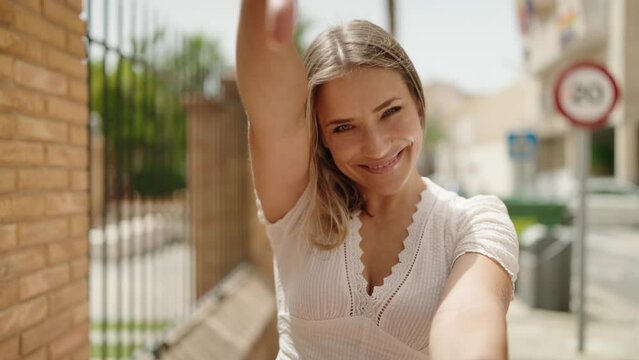 Young caucasian woman smiling confident doing photo gesture with hands at street