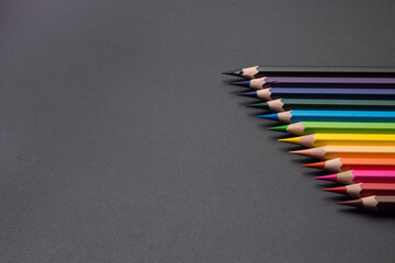Set of colored pencils, row of wooden colored pencils on black background. colored pencils for...