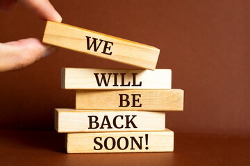 Wooden blocks with words 'We will be back soon!'.
