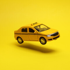 Miniature taxi car hovering in the air on yellow background with a shadow. Creative idea. Minimal concept. Levitating objects