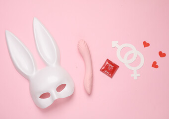 Accessories for sex games and safe sex on a pink background. Top view. Flat lay
