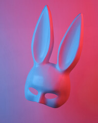 Sex shop rabbit mask floating in the air, isolated in blue-red neon gradient light. Levitating...