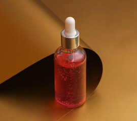 Facial serum bottle on a luxurious golden background