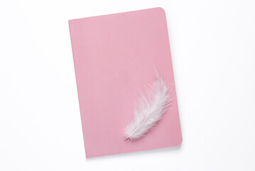 Notepad with feather on white background