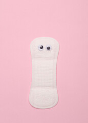 Intimate pad with eyes on a pink background. Creative idea