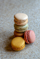 Delicious stack of french macarons stacked on a speckled counter top