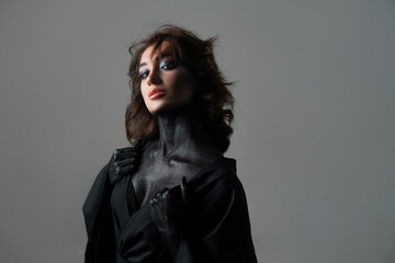 Glamorous gothic makeup with body art, beautiful young brunette in black, stylish portrait