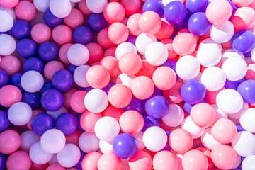 collection of pink, purple and white balls in a box